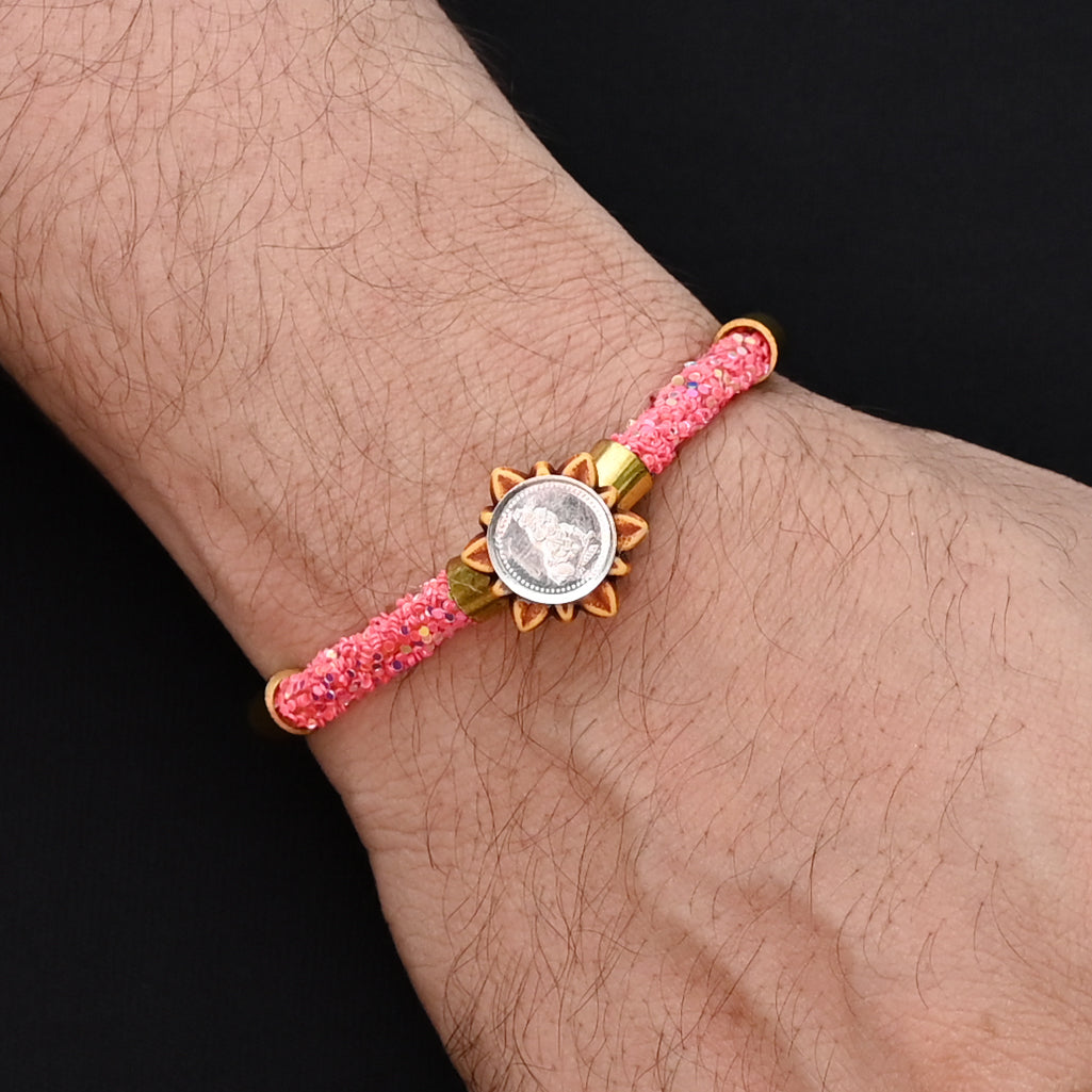 Traditional Rakhi for boys with silver Baal Gopal and pink flat circular beads