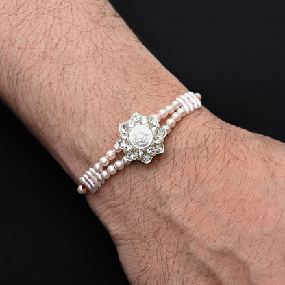 Elegant Ganesh Ji Rakhi with pearl accents, ideal for boys.