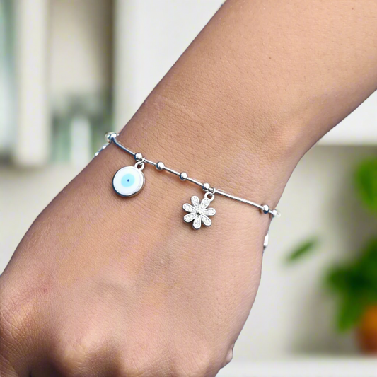 Elegant silver bracelet with a flower-shaped evil eye charm, symbolizing safety and positive energy.