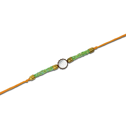 Boys' Rakhi featuring a silver Om centerpiece and green flat circular plastic beads