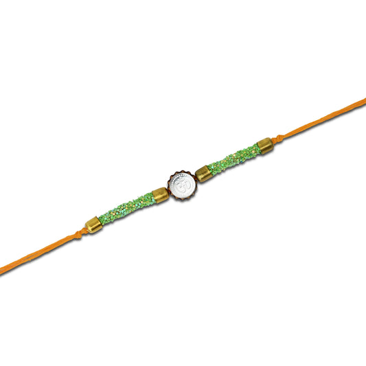 Boys' Rakhi featuring a silver Om centerpiece and green flat circular plastic beads