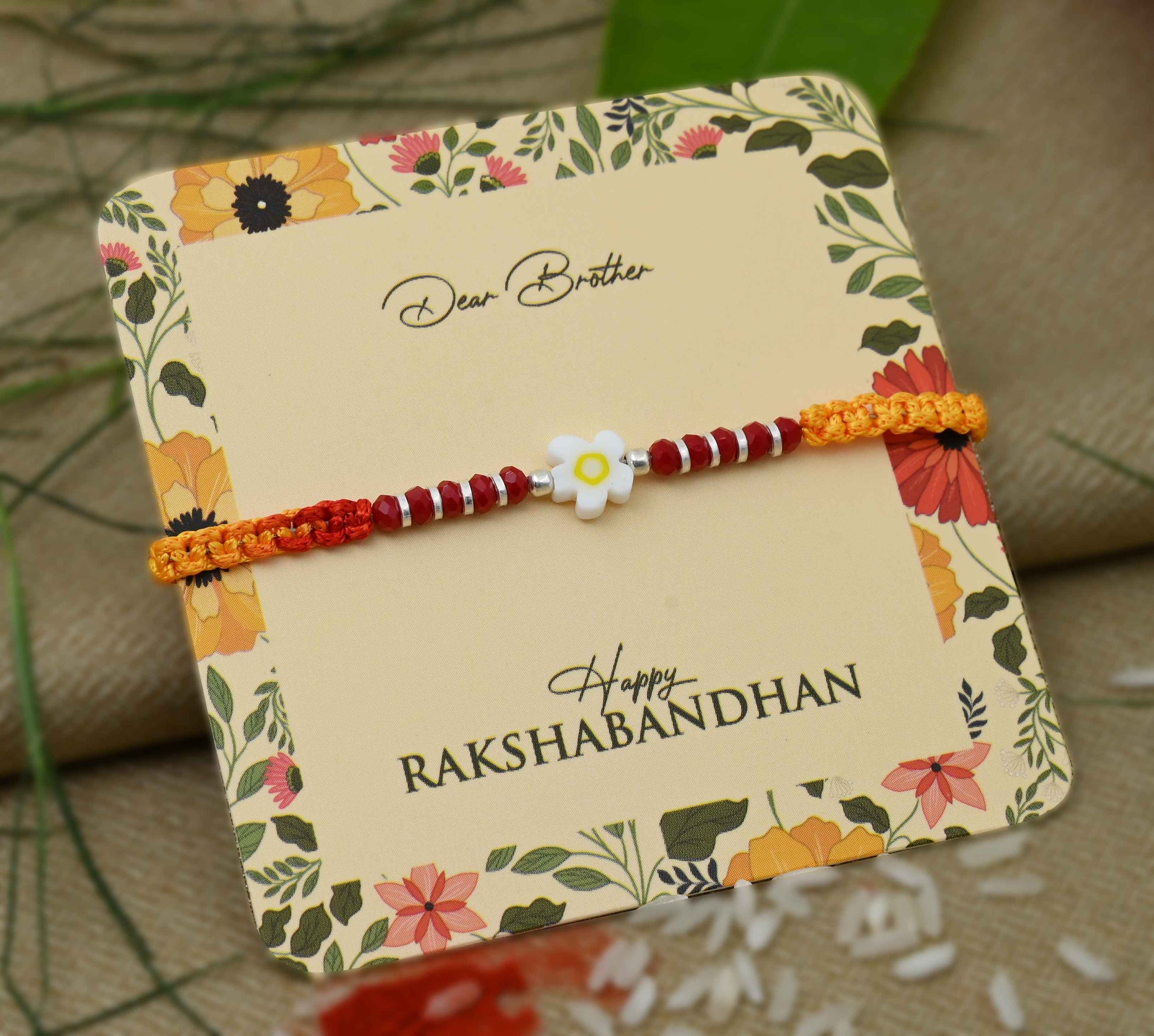 Silver center white flower design with silver and light red beads, perfect Rakhi for boys.