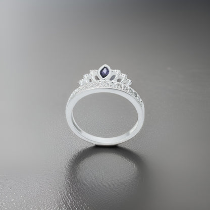 Close-up of a silver ring for girls, showcasing a stunning purple gem in the center of a crown-inspired design.