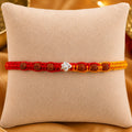 925 Silver Om Rudraksha Rakhi with authentic Rudraksha beads on a beige cushion for Raksha Bandhan gift for brother.