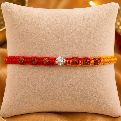 925 Silver Om Rudraksha Rakhi with authentic Rudraksha beads on a beige cushion for Raksha Bandhan gift for brother.