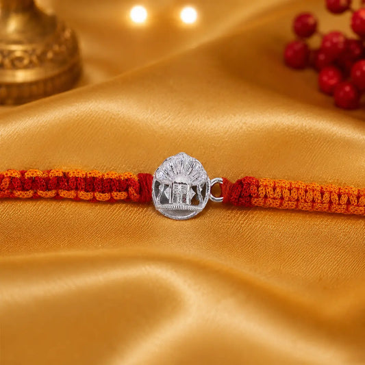 925 Sterling Silver Shivling Rakhi with traditional red and orange braided thread for Raksha Bandhan displayed on a premium beige velvet cushion.