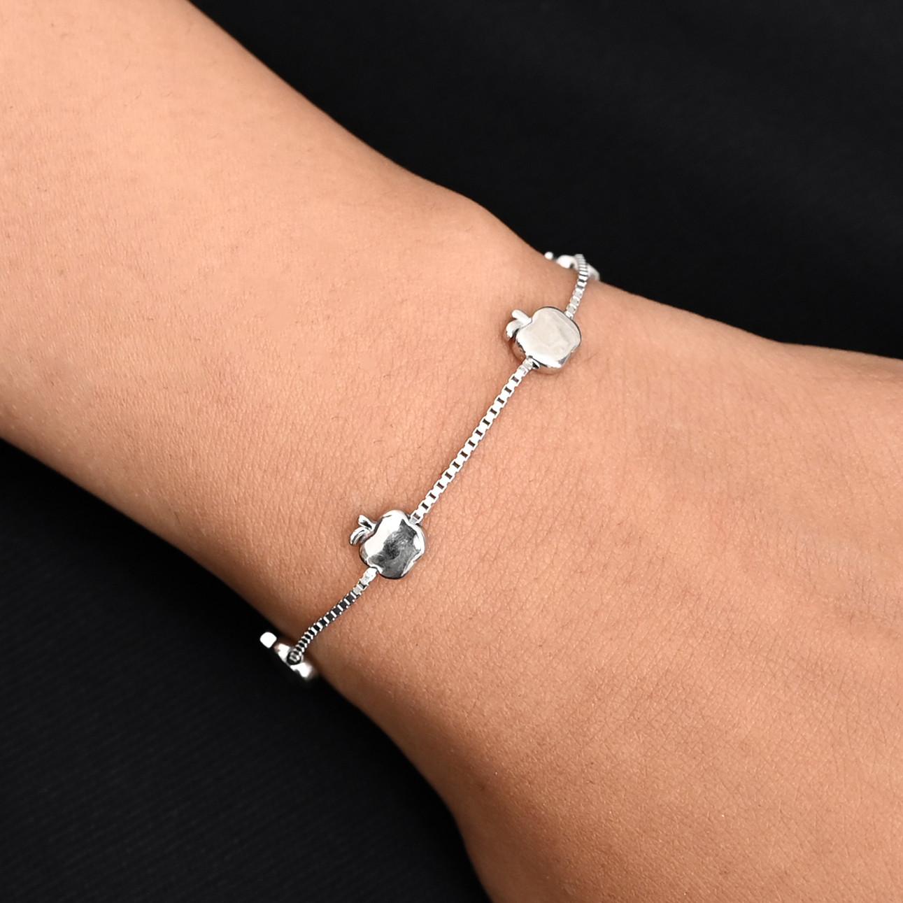 Silver bracelet featuring elegant symbols inspired by the iconic Apple brand, exuding sophistication.