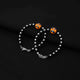 Stylish bracelet combining silver and black beads with a vibrant orange teddy bear centerpiece