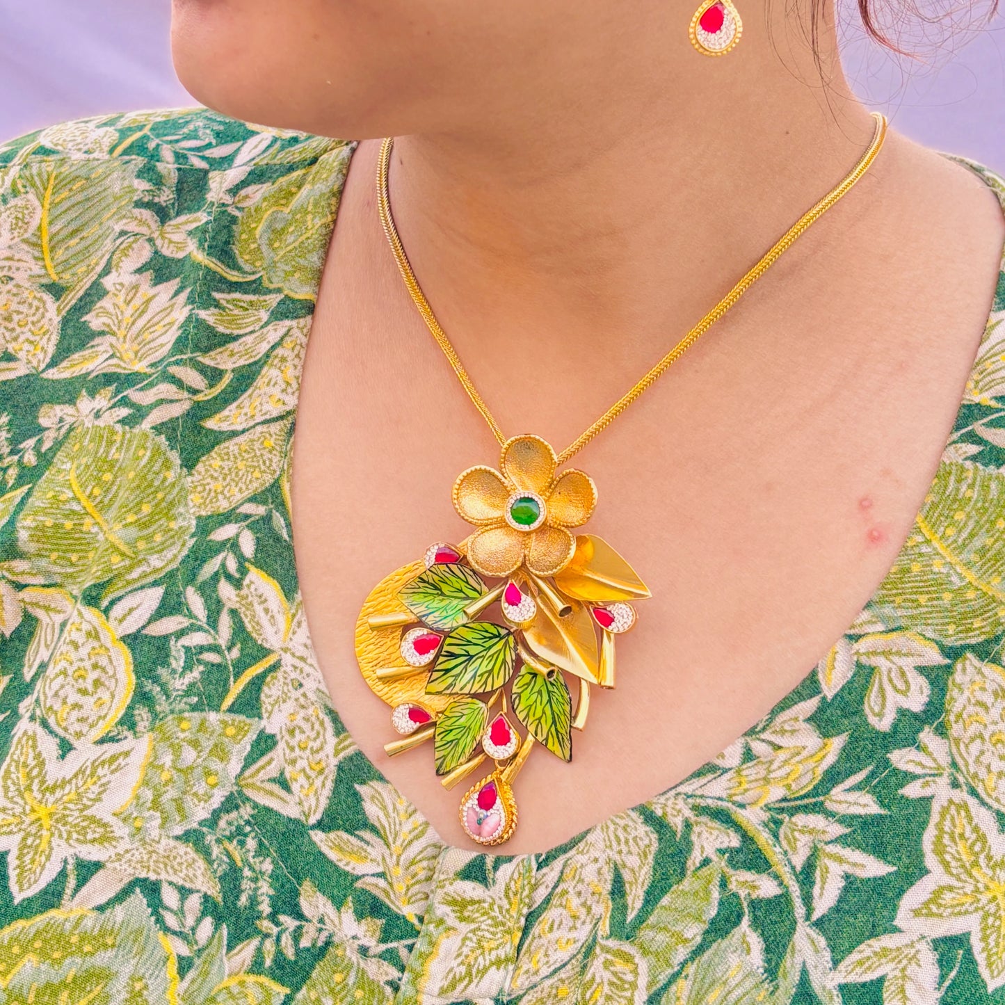 Charming Gold Polish Silver Necklace with Large Flower Center, Gold Leaves, and Pink Gemstones.