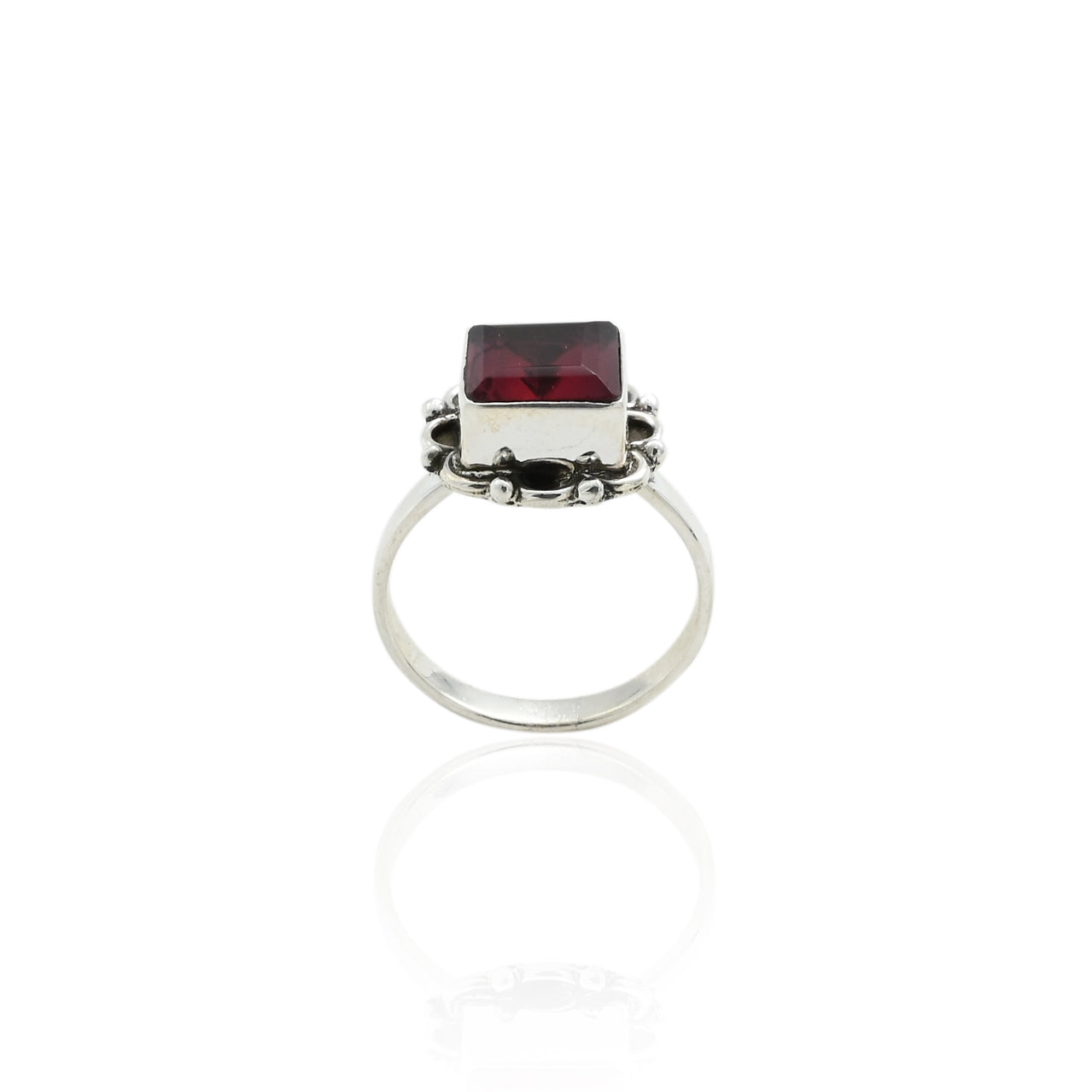 Close-up of a silver ring with a beautiful dark maroon gemstone, creating a bold and sophisticated design