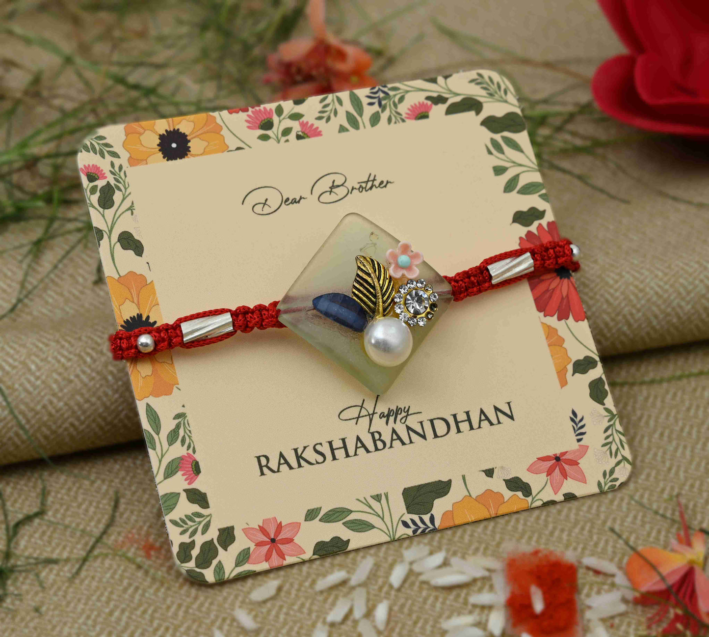 Silver Rakhi with pearl and flower design, perfect for boys.