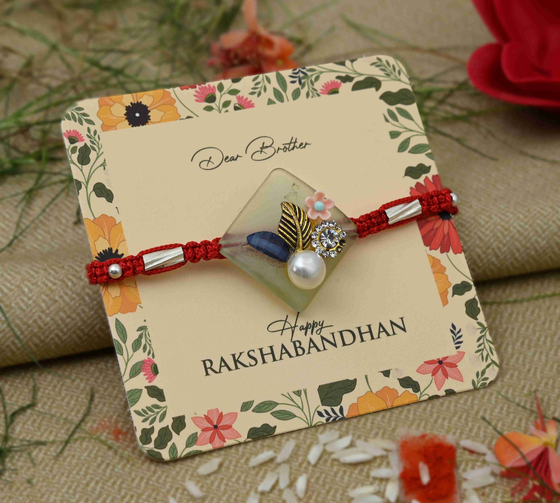 Silver Rakhi with pearl and flower design, perfect for boys.