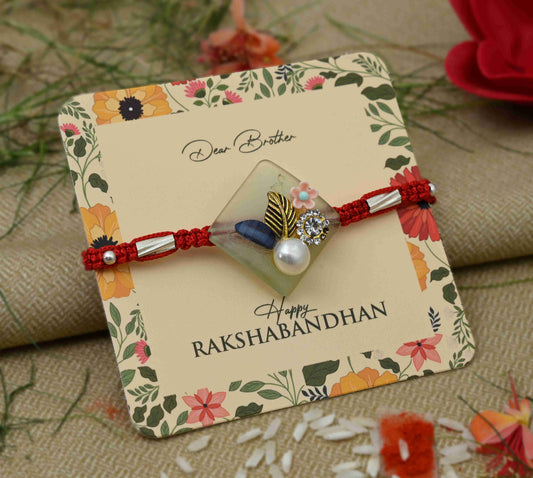 Silver Rakhi with pearl and flower design, perfect for boys.