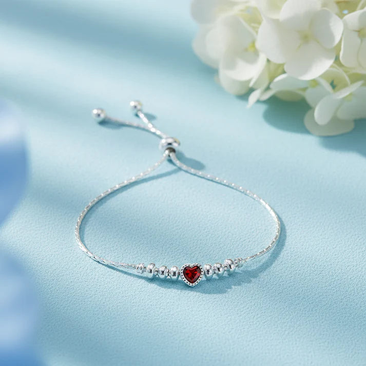 925 sterling silver adjustable bracelet with a Red heart-shaped gemstone, silver beads, and sliding clasp displayed on a light Red velvet jewelry box.
