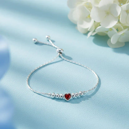 925 sterling silver adjustable bracelet with a Red heart-shaped gemstone, silver beads, and sliding clasp displayed on a light Red velvet jewelry box.