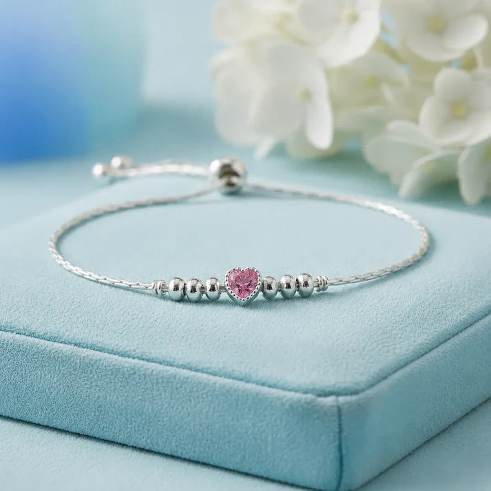 925 sterling silver adjustable bracelet with a purple heart-shaped gemstone, silver beads, and sliding clasp displayed on a light Pink  velvet jewelry box.