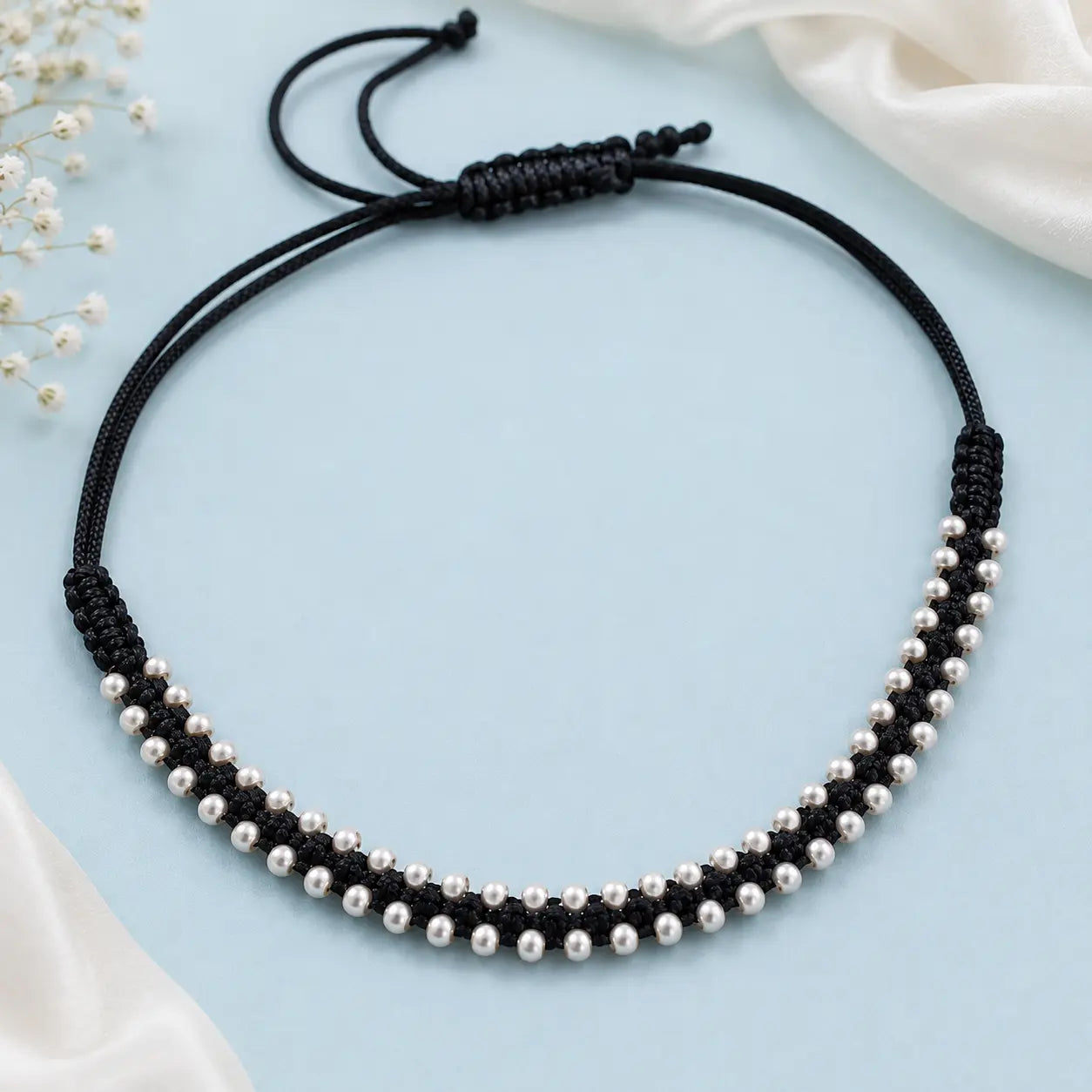 Black thread anklet with silver beads worn on a woman's anklet