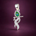 Silver Krishna flute pendant with colorful peacock feather design and sparkling white stones on a champagne-gold background