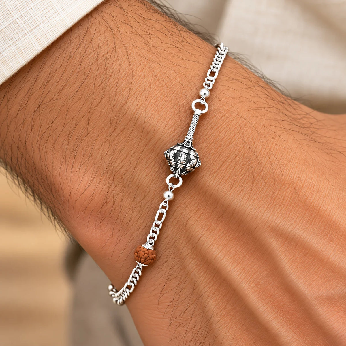 Hanuman Ji Ki Ghota silver bracelet with decorative silver chain and brown Rudraksha-style bead on a brown jewellery display