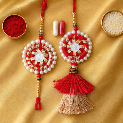 Traditional Om Swastik Pearl Lumba Rakhi Set for Bhaiya Bhabhi with white pearl border, red thread, golden beads and decorative Lumba tassel for Raksha Bandhan.