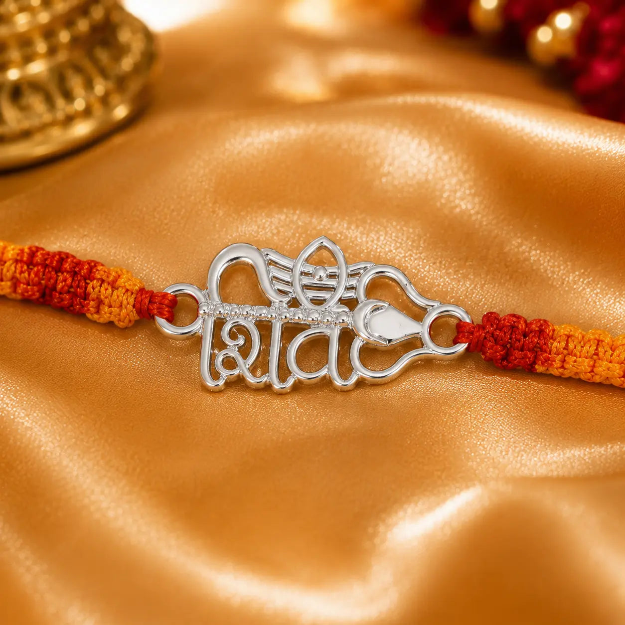 Shiv silver rakhi with Hindi Shiv symbol and Trishul design on red yellow thread placed on velvet cushion