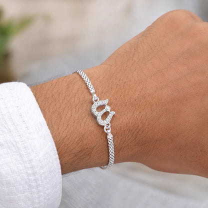Silver Trishul Bracelet with stone-studded Shiva design on a pastel blue background