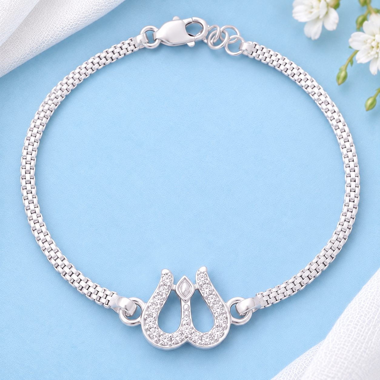 Silver Trishul Bracelet with stone-studded Shiva design on a pastel blue background