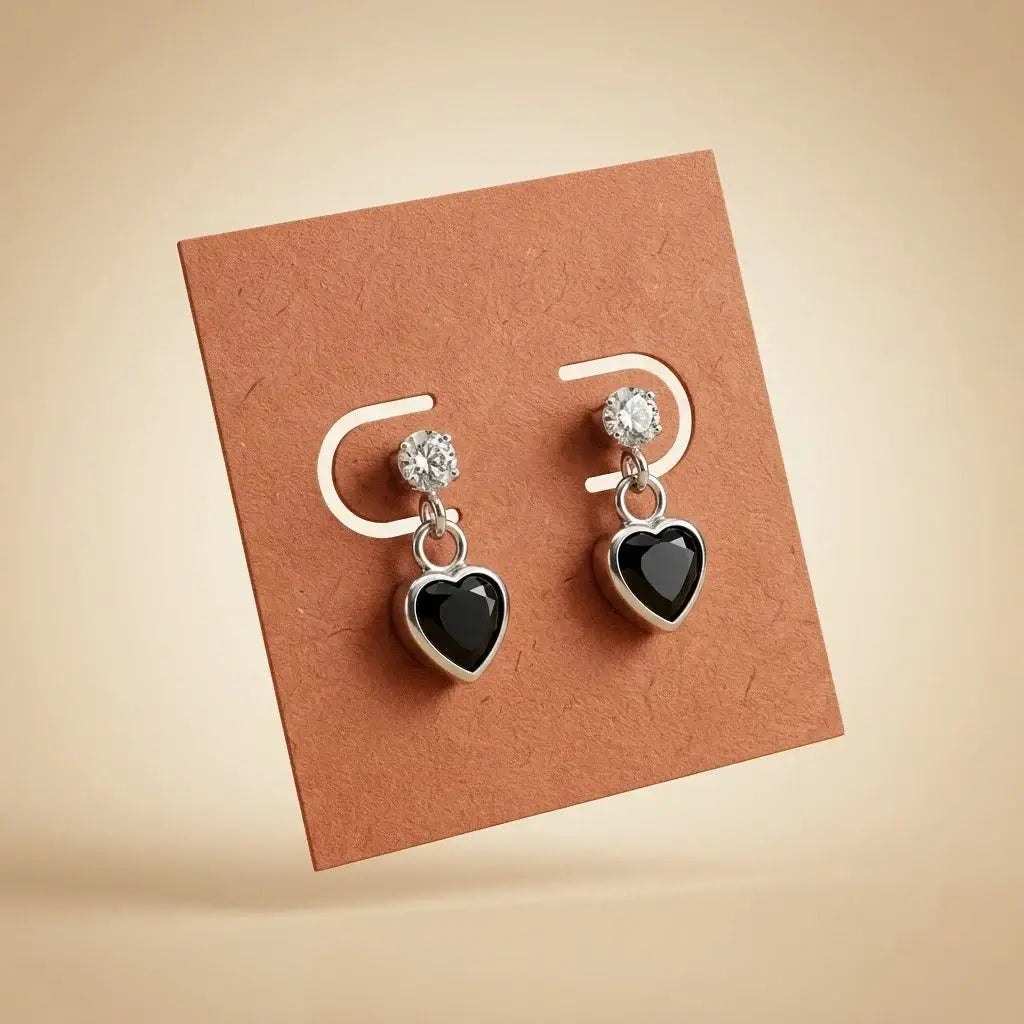 Silver black heart drop stud earrings with sparkling Cubic Zirconia stones and polished silver-tone finish for women displayed on a jewelry card.