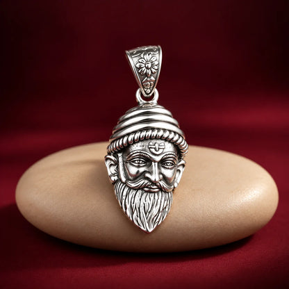 Silver Chhatrapati Shivaji Maharaj face pendant with detailed royal headgear, moustache, and beard on a white and dusty pink background