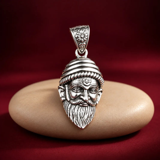 Silver Chhatrapati Shivaji Maharaj face pendant with detailed royal headgear, moustache, and beard on a white and dusty pink background