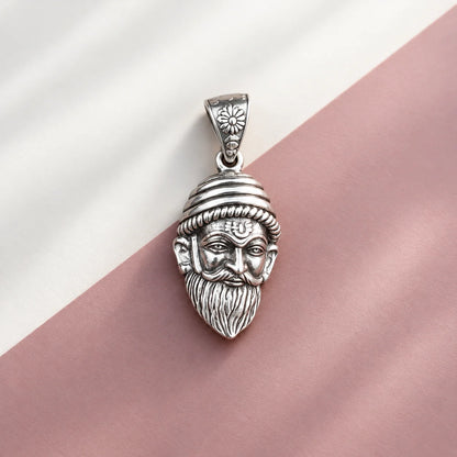 Silver Chhatrapati Shivaji Maharaj face pendant with detailed royal headgear, moustache, and beard on a white and dusty pink background