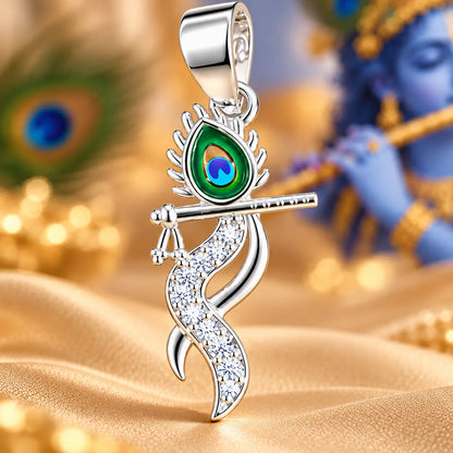 Silver Krishna flute pendant with colorful peacock feather design and sparkling white stones on a champagne-gold background