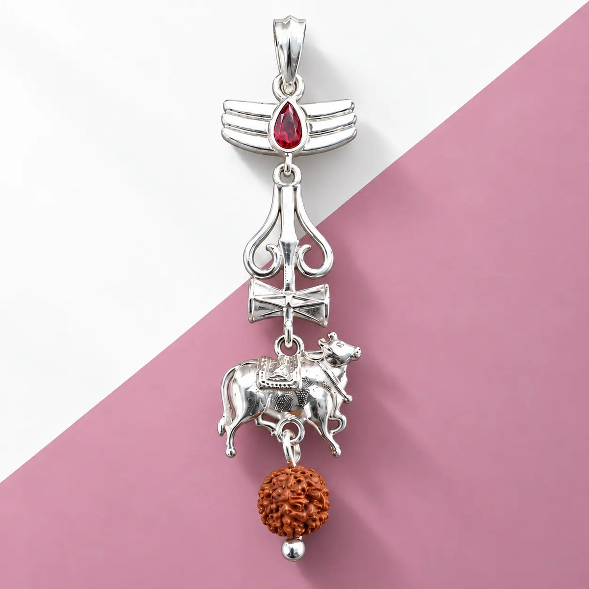Silver Nandi Mahadev Trishul pendant with red gemstone and Rudraksha bead on a pale sage green background