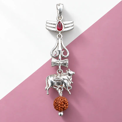 Silver Nandi Mahadev Trishul pendant with red gemstone and Rudraksha bead on a pale sage green background