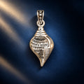 Silver Shankh pendant with engraved Sanskrit mantra and polished shell-shaped design on a pale sage green background