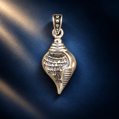 Silver Shankh pendant with engraved Sanskrit mantra and polished shell-shaped design on a pale sage green background