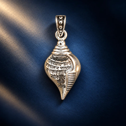 Silver Shankh pendant with engraved Sanskrit mantra and polished shell-shaped design on a pale sage green background