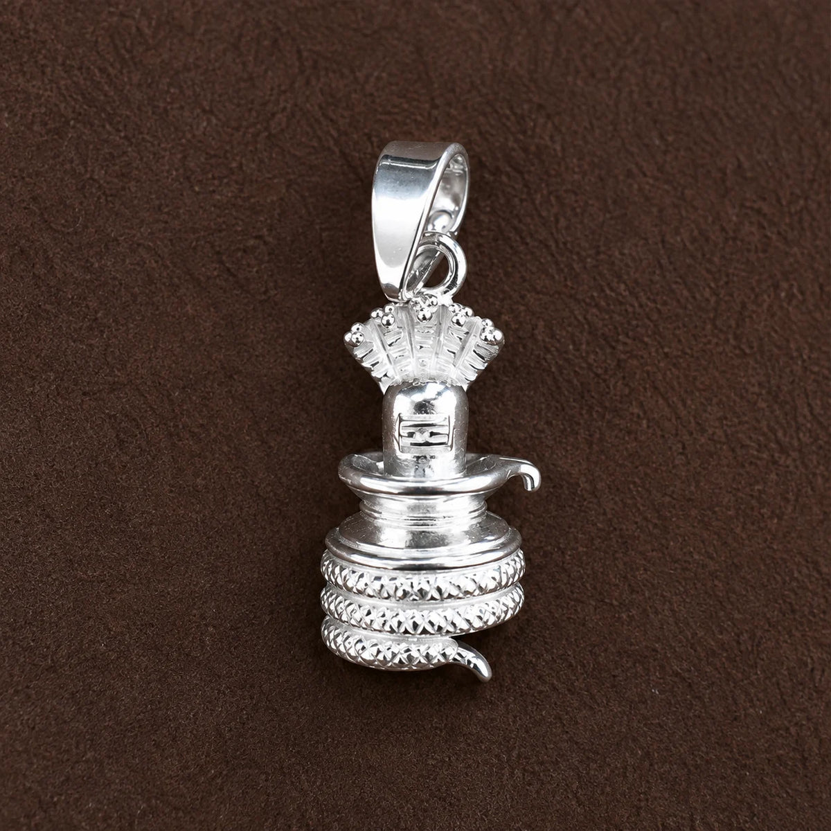 Silver Shivling pendant with cobra hood and coiled Naag design on a dark brown textured background