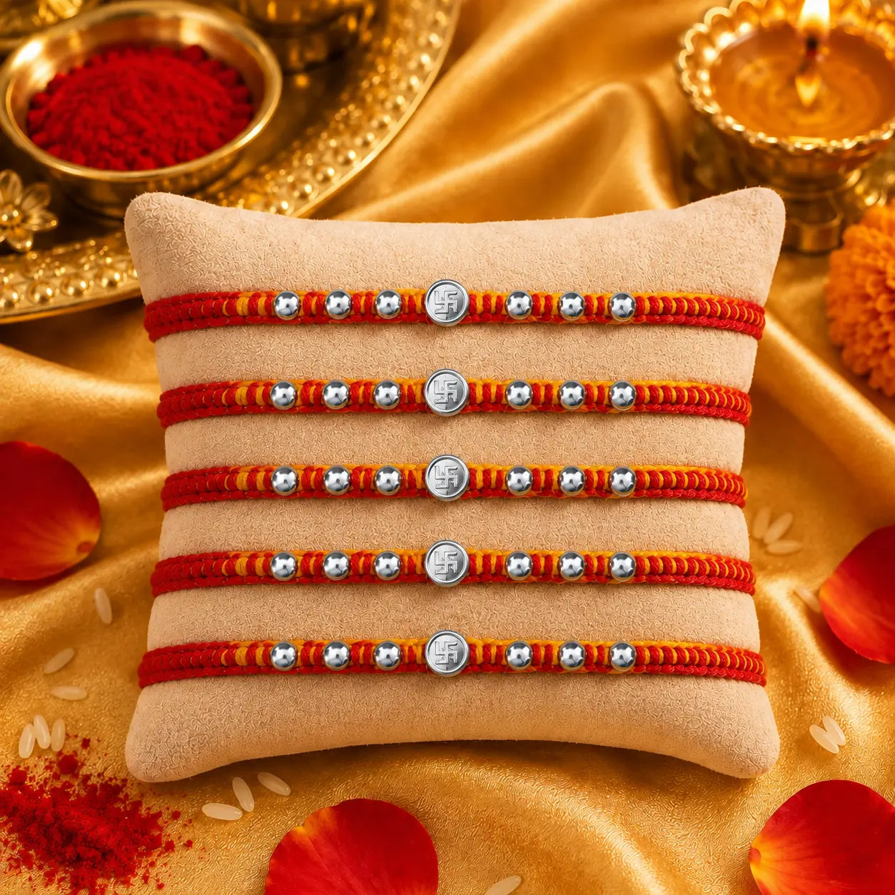 Premium silver Swastik Rakhi with red and yellow thread and silver beads on a beige cushion