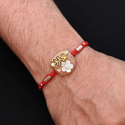 Elegant Rakhi with 'Bro' written in silver and adorned with a white flower, ideal for boys.