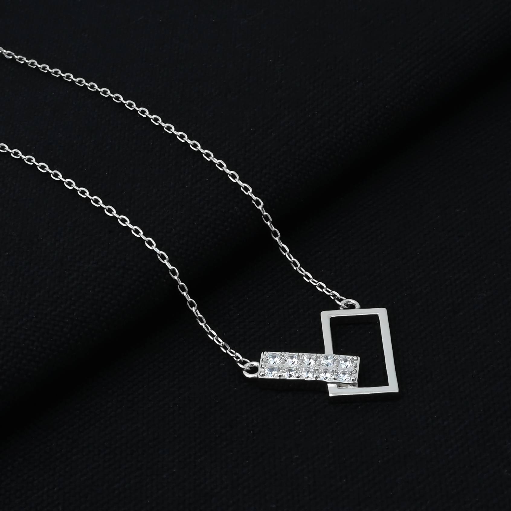 Stylish silver pendant with intersecting rectangles on a chain.