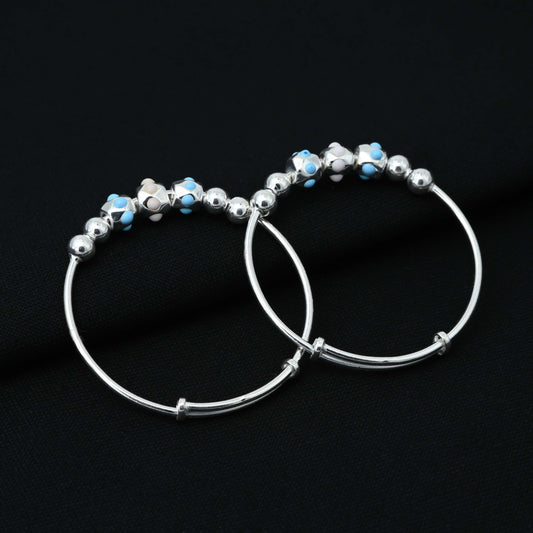 Stylish sterling silver baby bangles adorned with blue and beige dotted beads