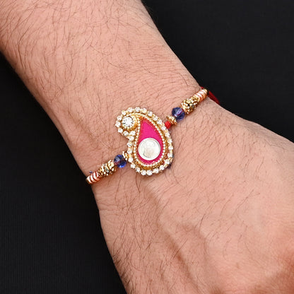 Elegant Ganesh Ji Rakhi with a pink background and multiple colorful beads, ideal for boys