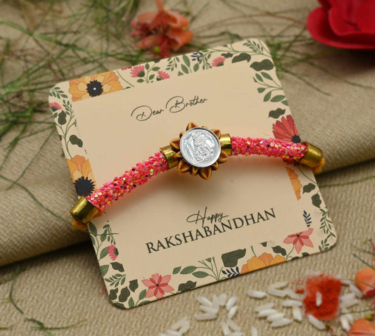 Silver Baal Gopal centerpiece with pink flat circular beads Rakhi for boys.