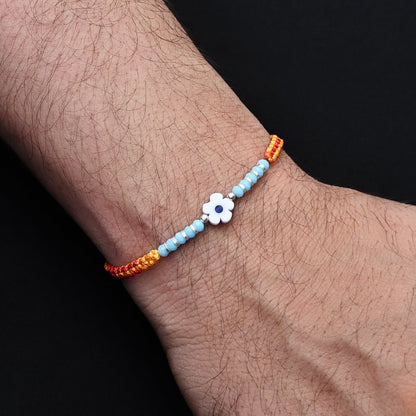 Elegant light blue flower design with silver and light blue beads, ideal Rakhi for boys.