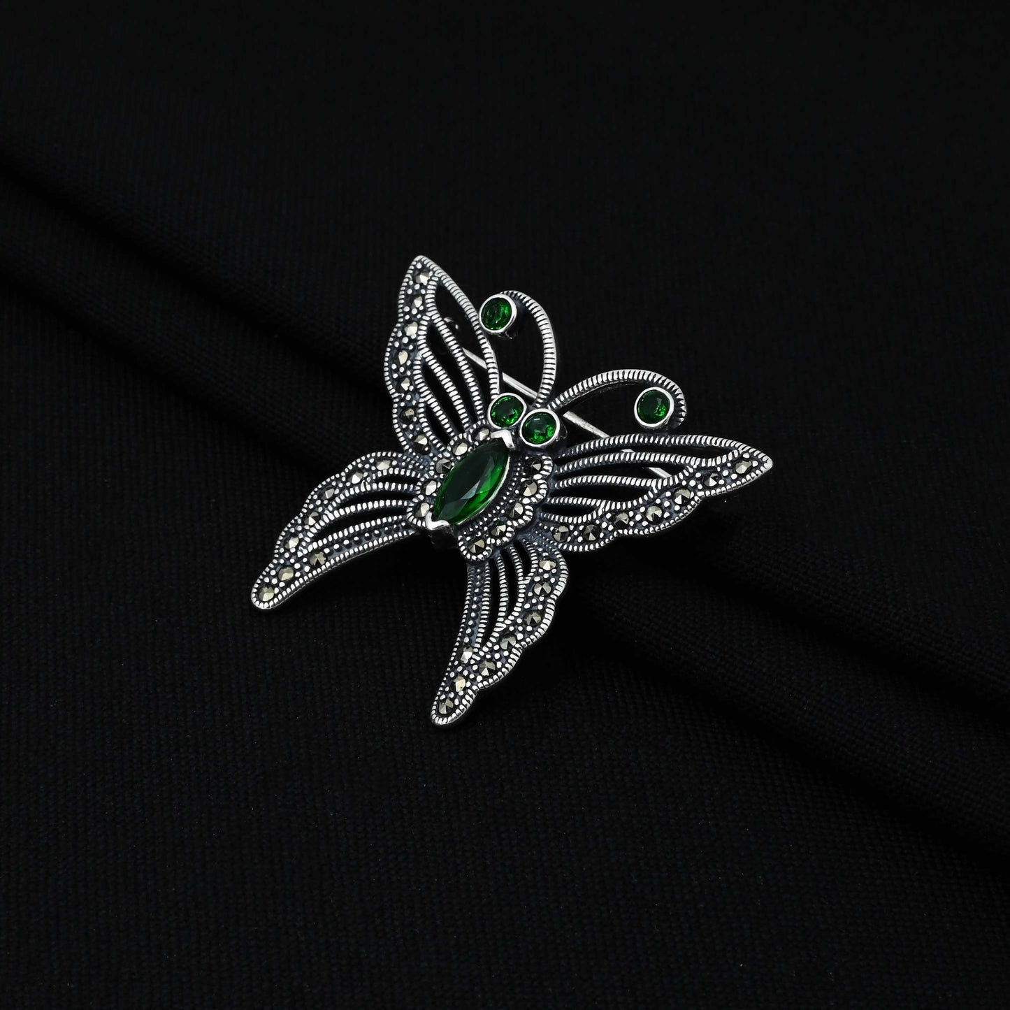 Silver saree pin with green stone butterfly motif, perfect for adding a graceful and colorful accent