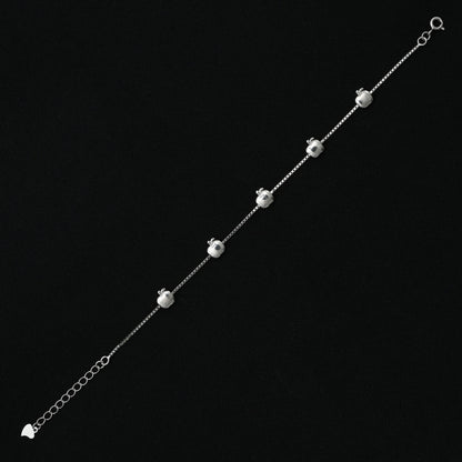 Charming silver bracelet adorned with unique symbols, reflecting the elegance of the Apple brand