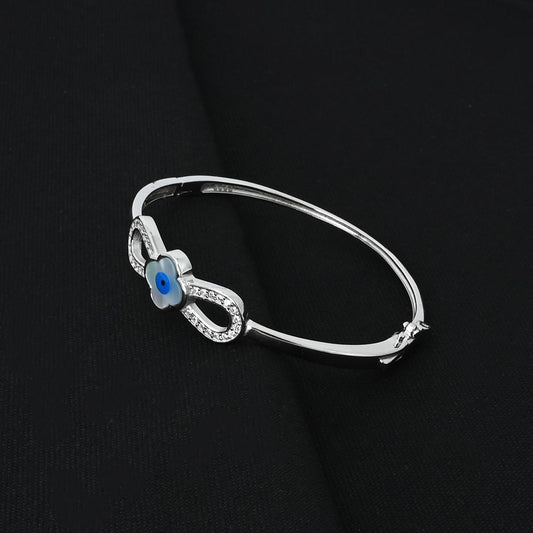 Elegant silver kada adorned with a fashionable evil eye charm