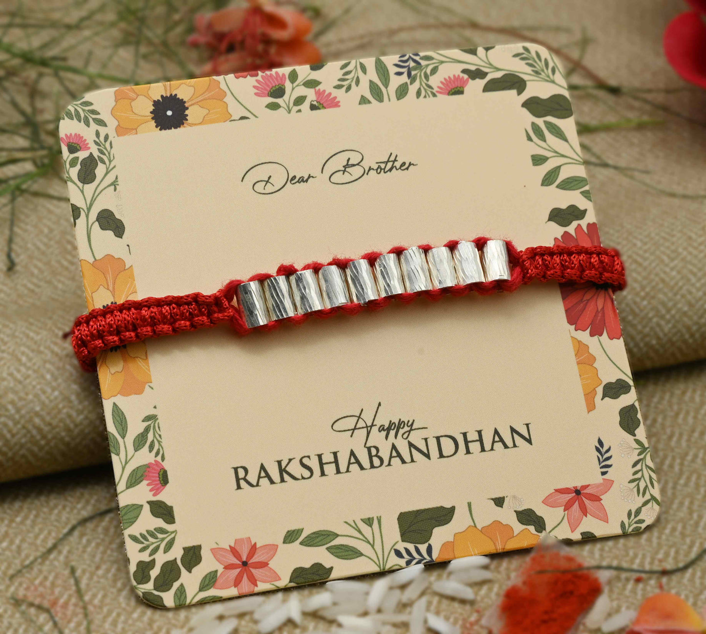 Silver Rakhi with multiple cylinder-shaped beads, perfect for boys