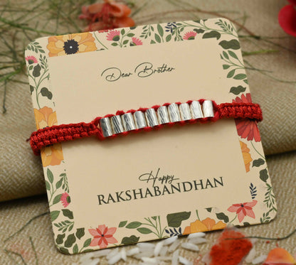 Silver Rakhi with multiple cylinder-shaped beads, perfect for boys